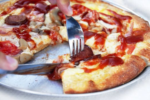 eating pizza closeup with knife and fork