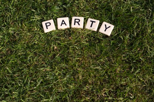 Party written in tiles on green grass