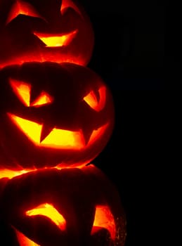 Illuminated cute halloween pumpkins isolated on black background