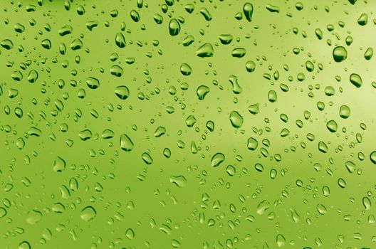 Water droplets on the glass with a colored background. Drops of water.