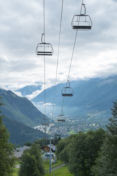 LES HOUCHES, FRANCE - AUGUST 23: Low angle shot of alpine air lift with Les Houches in the background. Les Houches is one of the Tour du Mont Blanc villages. August 24, 2014 in Les Houches.