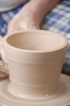 Hands of a potter, creating an earthen jar on the circle