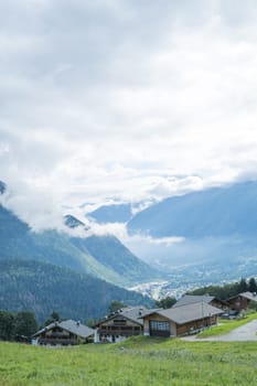 COL DE VOZA, FRANCE - AUGUST 24: Chalets with Les Houches village in the background. Les Houches is one of the Tour du Mont Blanc villages. August 24, 2014 in Col de Voza.
