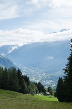 COL DE VOZA, FRANCE - AUGUST 24: Chalets with Les Houches village in the background. Les Houches is one of the Tour du Mont Blanc villages. August 24, 2014 in Col de Voza.