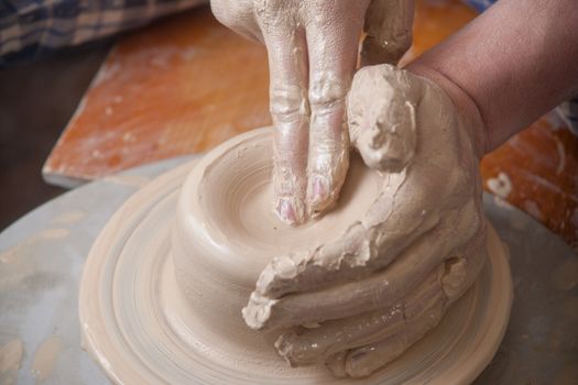 Hands of a potter, creating an earthen jar on the circle