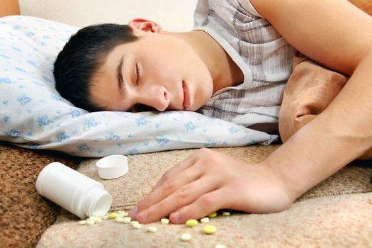Teenager sleeps near the scattered Pills on the Bed at the Home