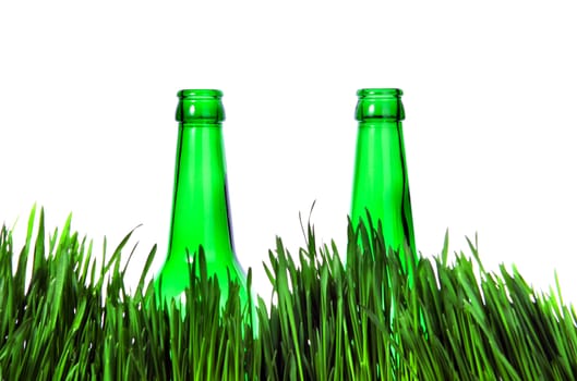 Two Green Bottles in the Grass Isolated on the White Background