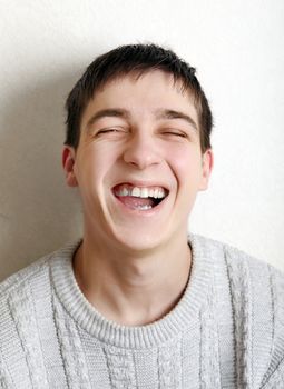 Happy Teenager laughing near the wall at the Home