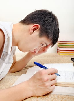 Side view of the Teenager doing Homework at the Home