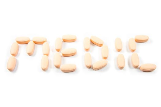 Word medic made with medicine pills isolated on white background