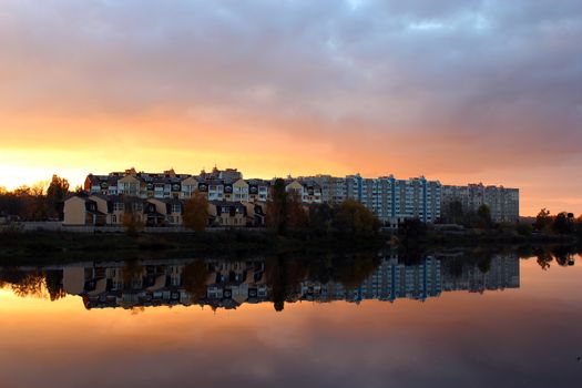 beautiful landscape with sunset, river and modern house reflecting in it