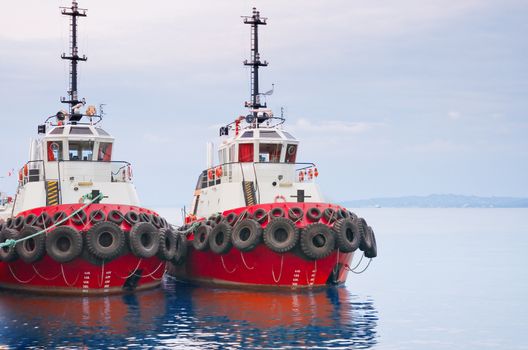 A red tugboats are moored in the harbor
