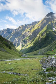 LES CHAPIEUX, FRANCE - AUGUST 27: Mountains chain with lonely chalet at the hill side. The region is a stage at the Mont Blanc tour, which crosses three countries. August 27, 2014 in Les Chapieux.