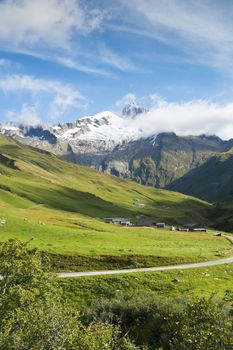 VILLE DES GLACIERS, FRANCE - AUGUST 27: Small village with Glacier Needles in the background. The region is a stage at the popular Mont Blanc tour. August 27, 2014 in Ville des Glaciers.