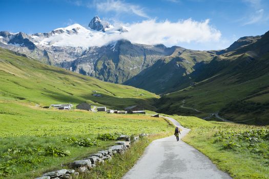 VILLE DES GLACIERS, FRANCE - AUGUST 27: Hiker walking towards Glacier Needles. The region is a stage at the Mont Blanc tour, which crosses three countries. August 27, 2014 in Ville des Glaciers.