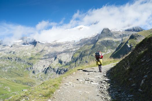 VILLE DES GLACIERS, FRANCE - AUGUST 27: Hiker walking towards Glacier Needles. The region is a stage at the Mont Blanc tour, which crosses three countries. August 27, 2014 in Ville des Glaciers.