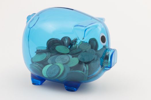 Blue transparent piggy bank with visible euro coins