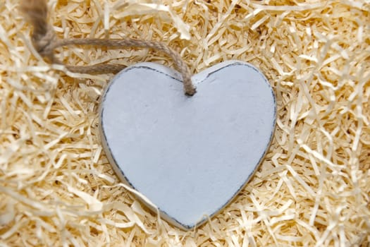 blank single grey wooden love heart in a love nest made of straw with copy space