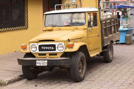 BANOS, ECUADOR - FEBRUARY 22, 2014: An old Toyota Land Crusier pick-up truck parked on the street Dr. Enrique Freire Guevara close to the bridge over the Pastaza River on February 22, 2014 in Banos, Ecuador. 