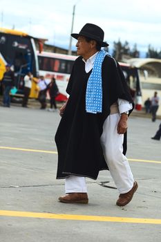 AMBATO, ECUADOR - MAY 12, 2014: Unidentified man in traditional clothes walking at the bus terminal on May 12, 2014 in Ambato, Ecuador. It's common to see people in traditional clothes in the Tungurahua Province.