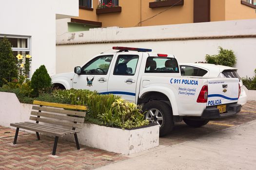 QUITO, ECUADOR - AUGUST 6, 2014: Police car parking in front of the building of the UPC (Unidad de Policia Comunitaria, Communitary Police Unit) on Gil. Ramirez Davalos Street on August 6, 2014 in Quito, Ecuador