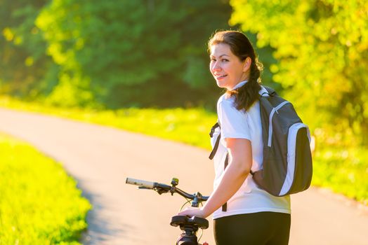 Brunette rides a bicycle on a sunny morning