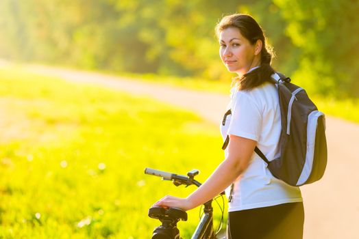 beautiful athlete with a backpack on a bicycle