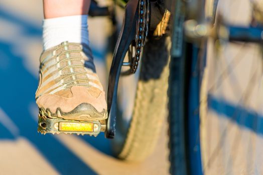 foot girl in sneakers on a bicycle pedal