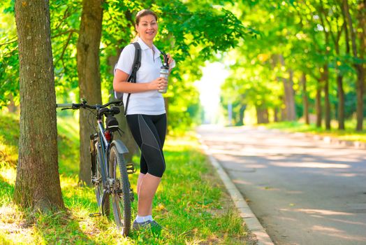 young girl resting in a park with a bicycle