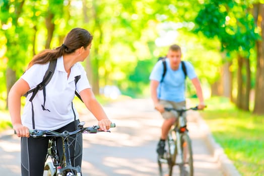 man and woman in the park on bicycles in the morning