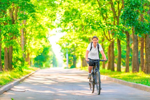 young girl on a bicycle in a park in the early morning