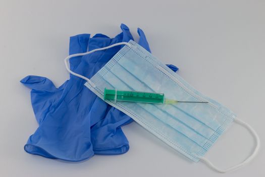 Protection against infection, mask, gloves and syringe on light background