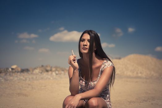 Lady in summer dress hitchhiking on a sunny day