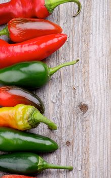 Frame of Red and Green Habanero and Jalapeño Chili Peppers isolated on Rustic Wooden background