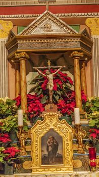 Old Mission Santa Ines Basilica Altar Cross Solvang California at Christmas.  Founded in 1804, 19 of 21 Missions in California.  Named for Saint Agnes, young Roman girl martyr, symbol of purity and chastity.