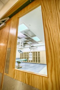 looking through a door glass window into a surgery room