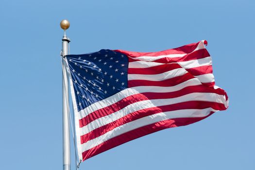 American flag fluttering on the blue sky