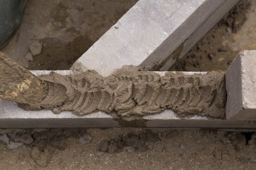 Putting concrete with a trowel on a constructed wall outdoors