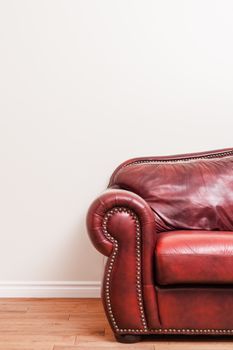 Luxurious Red Leather Couch Detail in front of a blank wall to ad your text, logo, images, etc.