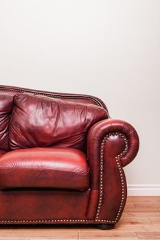 Luxurious Red Leather Couch Detail in front of a blank wall to ad your text, logo, images, etc.