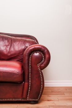 Luxurious Red Leather Couch Detail in front of a blank wall to ad your text, logo, images, etc.