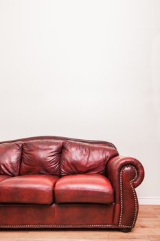 Luxurious Red Leather Couch in front of a blank wall to ad your text, logo, images, etc.