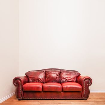 Luxurious Red Leather Couch in front of a blank wall to ad your text, logo, images, etc.