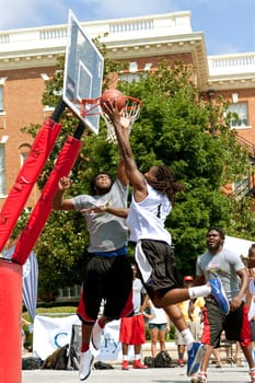 Athens, GA, USA - August 24, 2013:  A young man drives hard to the basket against a defender, in a 3-on-3 basketball tournament held on the streets of downtown Athens.