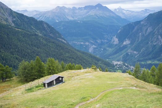 COURMAYEUR, ITALY - AUGUST 29: High angle view of chalet with Courmayeur valley in the background. The area is a stage of the popular Mont Blanc tour. September 29, 2014 in Courmayeur.