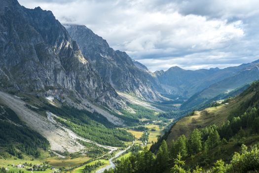 Early morning in Val Ferret valley in Italy, with overcast sky and rocky mountain range