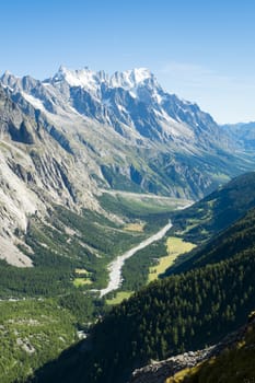 Val Veny valley in Val d'Aosta, in Italy, with Dora di Val Veny river and forests on hillsides.