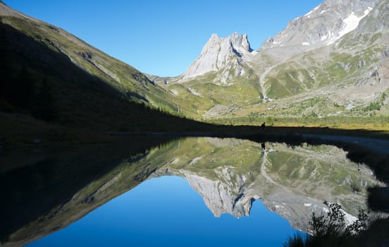 Limestone Pyramids reflected on Combal Lake waters in Val Veny, Italy