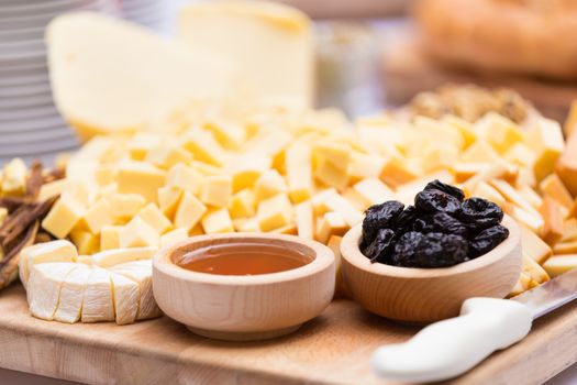 Cheese Plate with Dried Fruit and Honey. Rustic decoration on a wooden plate.