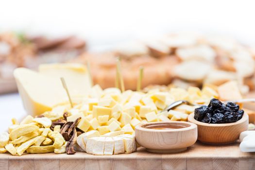 Cheese Plate with Dried Fruit and Honey. Rustic decoration on a wooden plate.